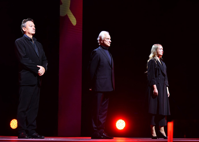 Anatolij, Molokov och Svetlana uppradade på scenen, mörkt klädda i rött ljus. 